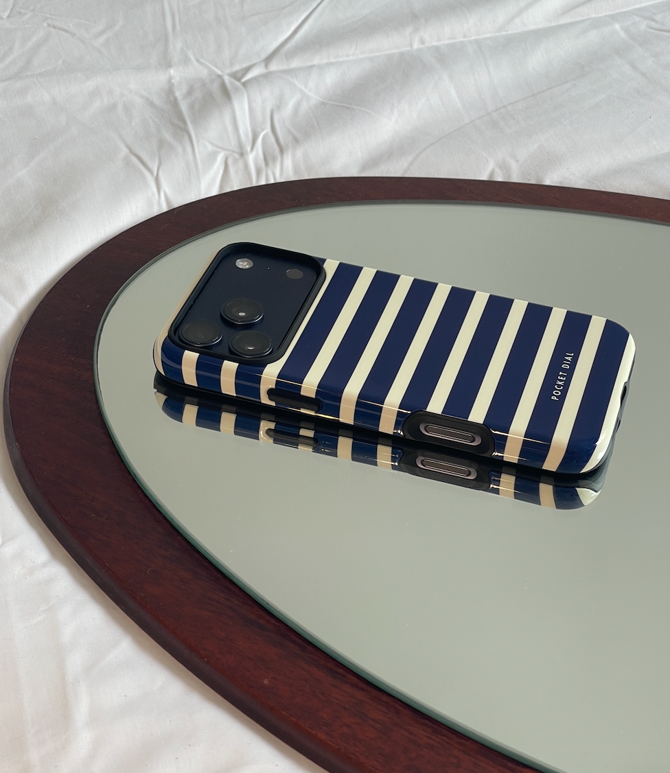 Pocket Dial navy and cream striped protective iPhone case on mirrored table